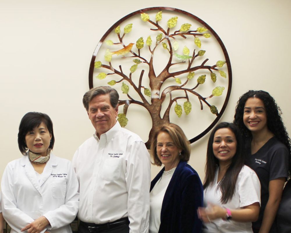 Clifton practice team group photo in front of decorative tree artwork